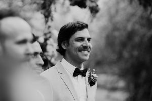groom smiling as he sees bride for the first time walking up the aisle at their luxury countryside wedding