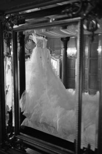 tulle wedding dress hanging on a royal bed frame